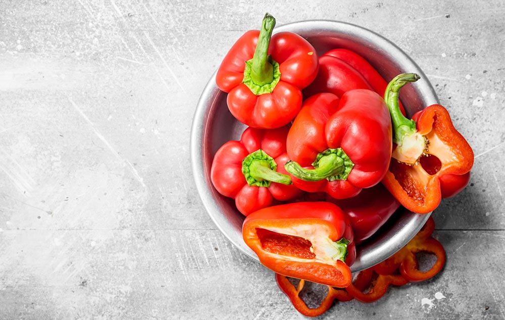 An overhead view of red capsicum in a bowl. 
