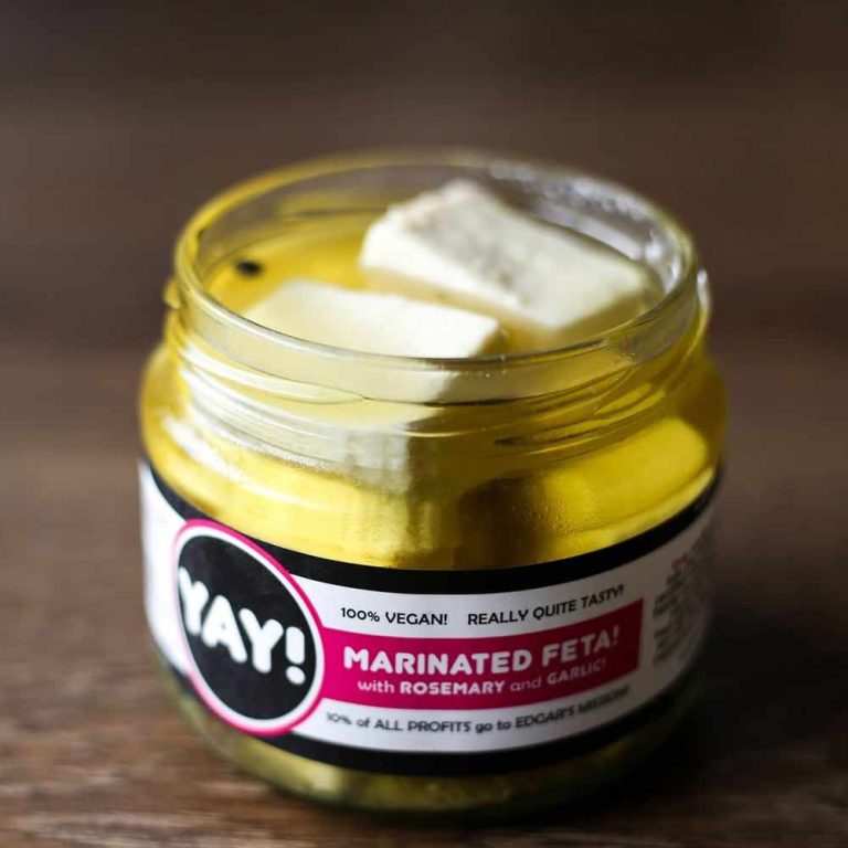 A jar of plant-based marinated dairy-free feta alternative with rosemary and garlic, labelled YAY! 100% vegan dairy-free snack.