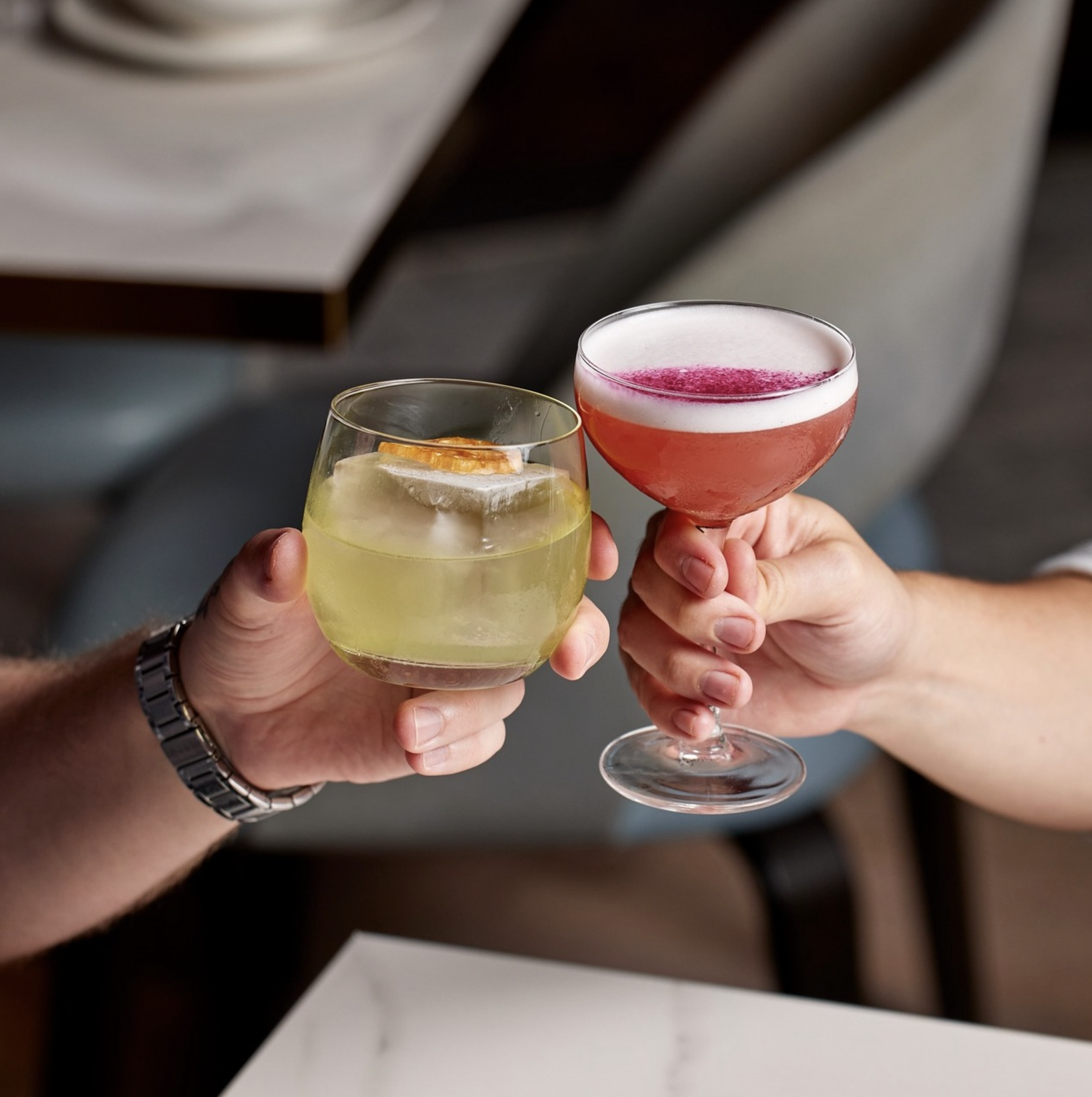 Two people clinking their vibrant cocktails at the Boom Boom Room