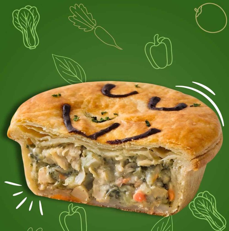 Best vegan sausage rolls & pies: A cross-section of a savoury pie filled with vegetables and plant-based chicken, set against a green background with line art of assorted vegetables.
