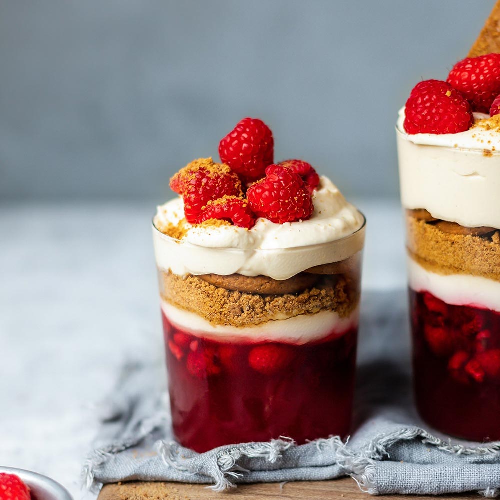 Clear glass cups filled with jelly cheesecake and topped with raspberries showcase what gelatine substitutes can do.