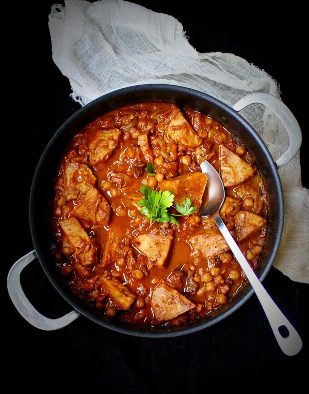 An overhead view of a Moroccan-style plant-based lamb tagine in a pot.