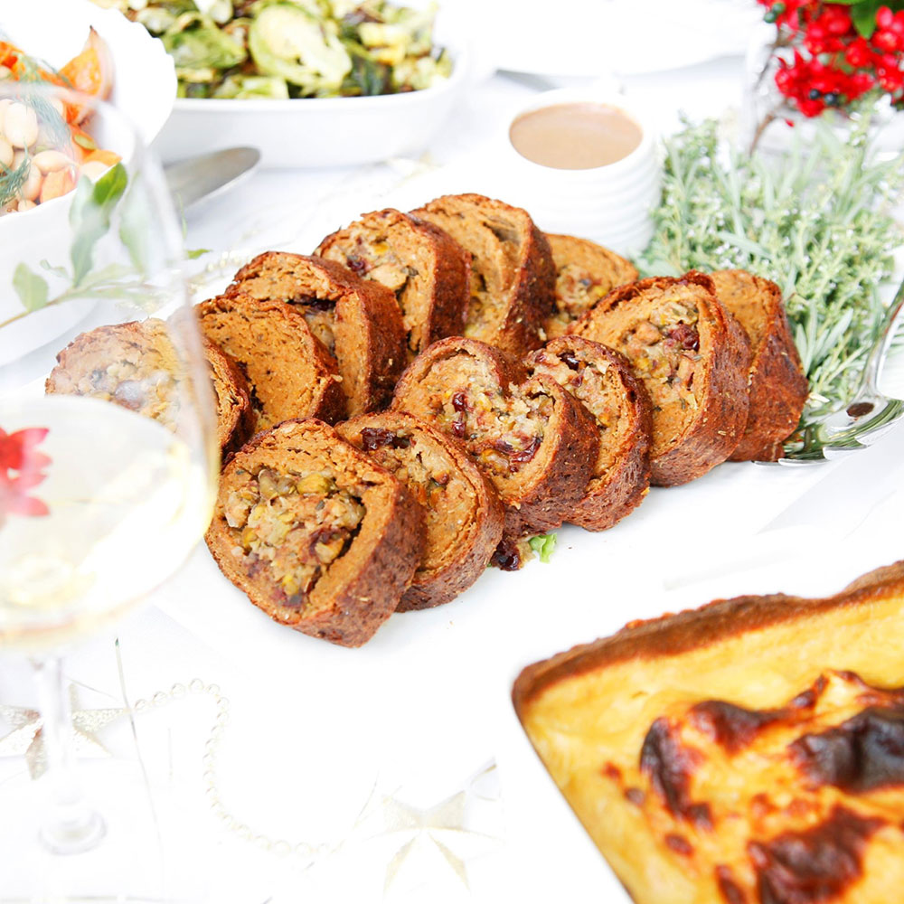 A platter of pistachio & cranberry stuffed seitan roast with onion gravy.