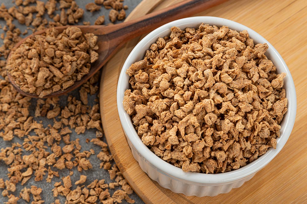 A bowl full of dehydrated textured vegetable protein granules.