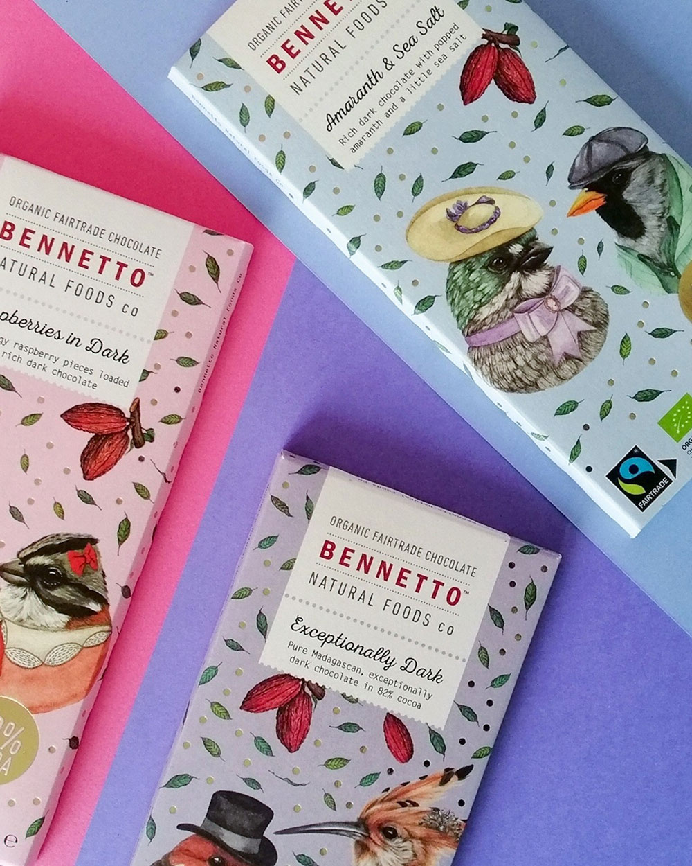 Three flavours of Bennetto chocolate blocks are laid out on a pastel, geometric background.