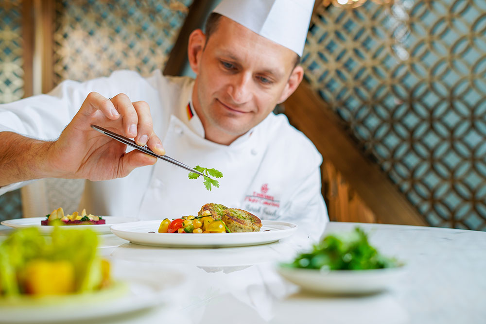 A chef making the finishing touches to one of their new vegan dishes.