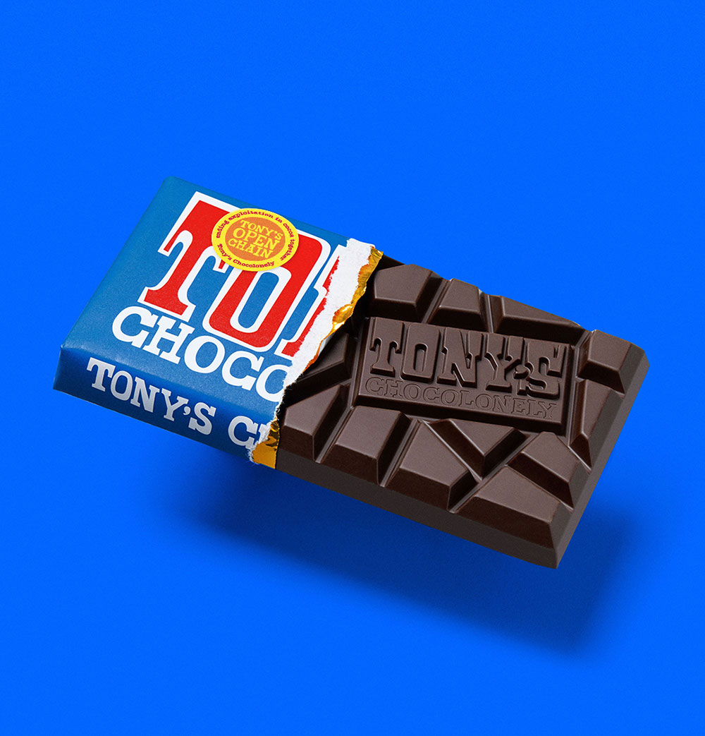 An open block of Tony's Chocolonely dark, opened and on a royal blue background.