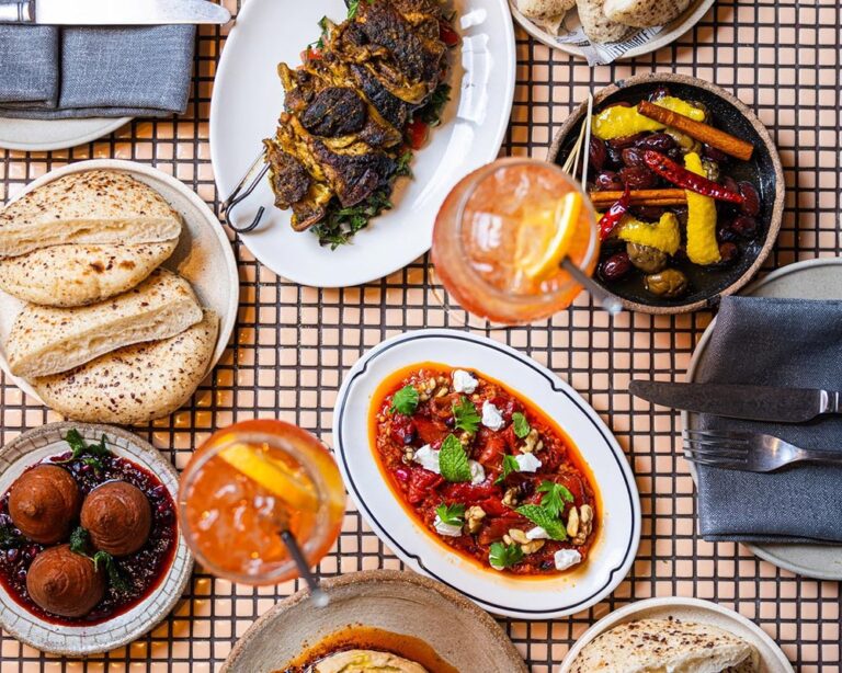 A plant-based spread from Za Za Ta taken overhead on a tiled bench.