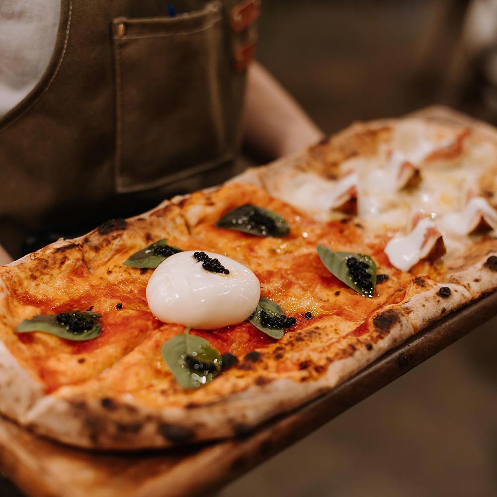 A simple rectangular vegan Margherita pizza on a wooden board.