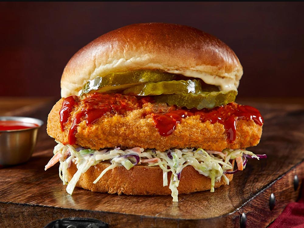 A Quorn vegan chicken burger served with slaw and pickles. 