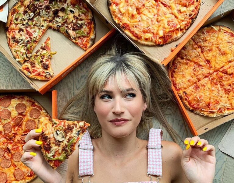 vegan youtube channels: Candace from Edgy Veg lies on the floor looking up, surrounded by vegan pizzas.