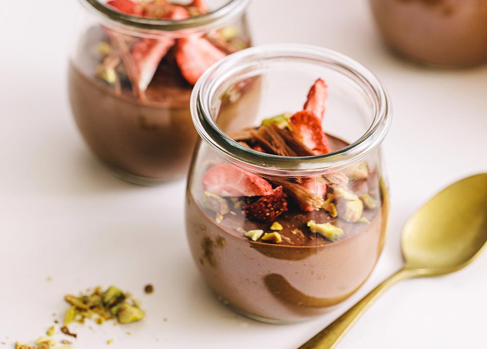 Vegan desserts: Close-up of a glass of chocolate mousse topped with strawberries.