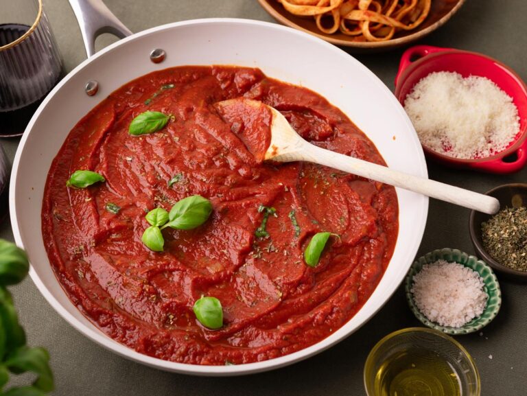 A bowl of Napoli sauce topped with fresh basil