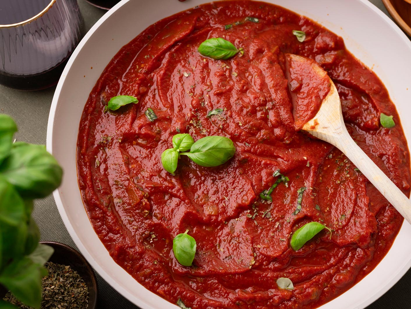A bowl of Napoli sauce topped with fresh basil