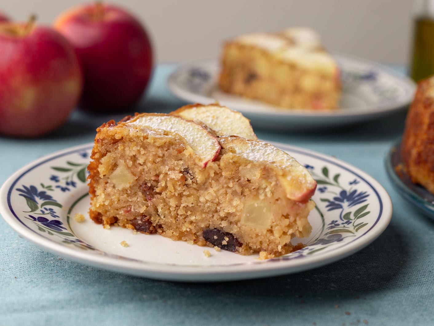 A slice of apple cake is served on a small dessert plate.