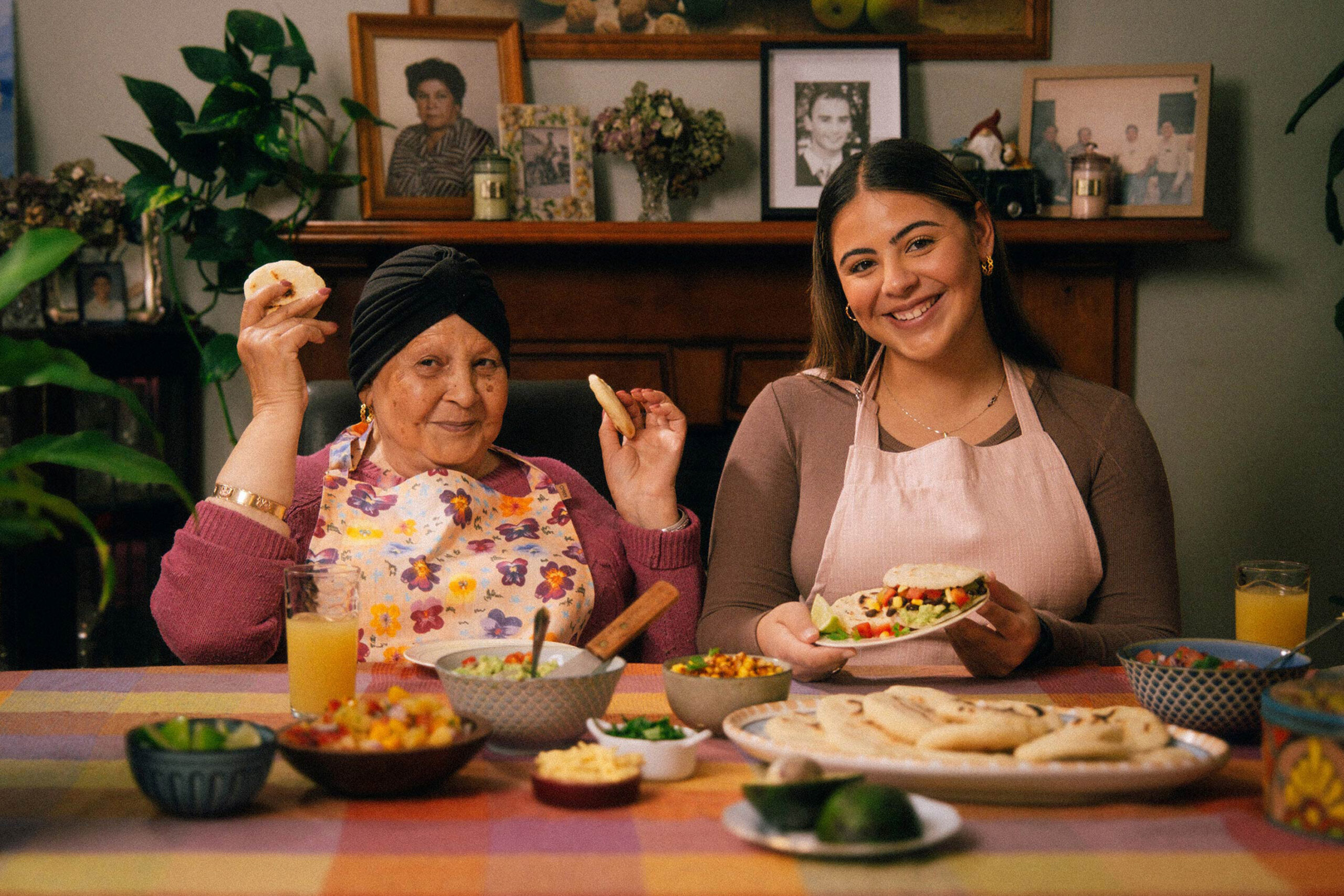 Nanna sitting at her dining table with her granddaughter Georgia with a plate of fresh arepas in front of them.