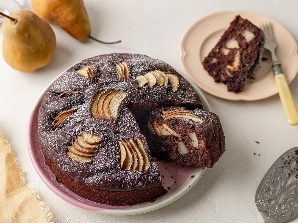 A rich chocolate and pear cake dusted with icing sugar.