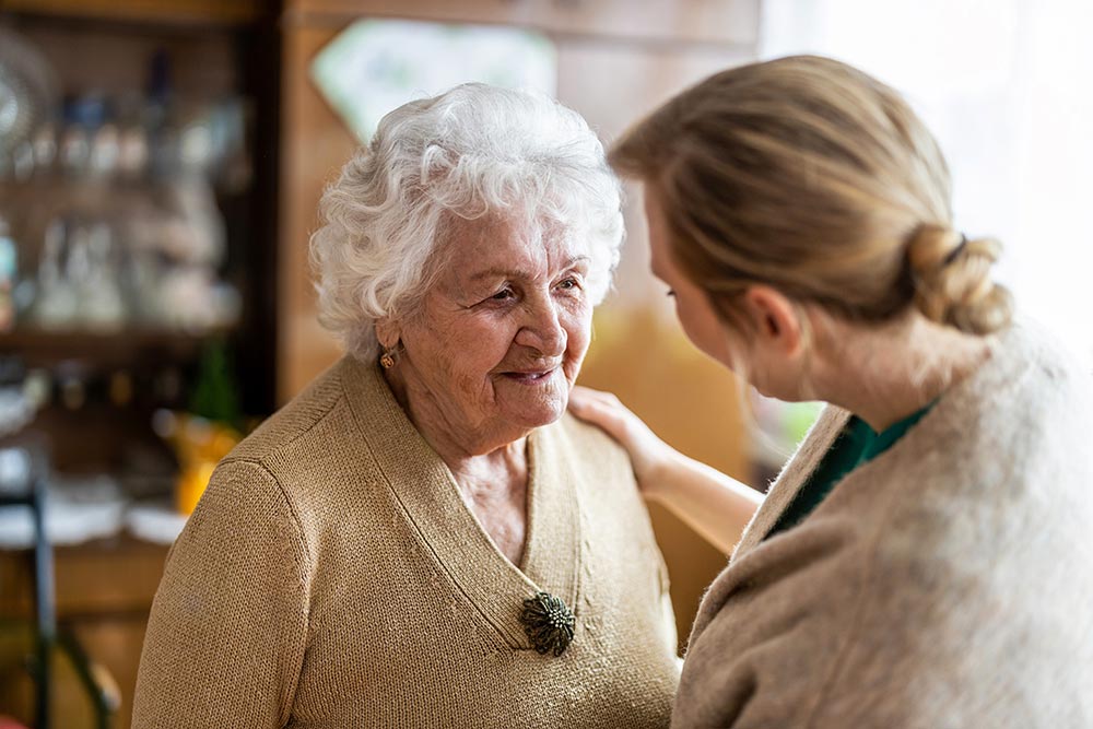 A healthcare worker talks to a patient with dementia. 