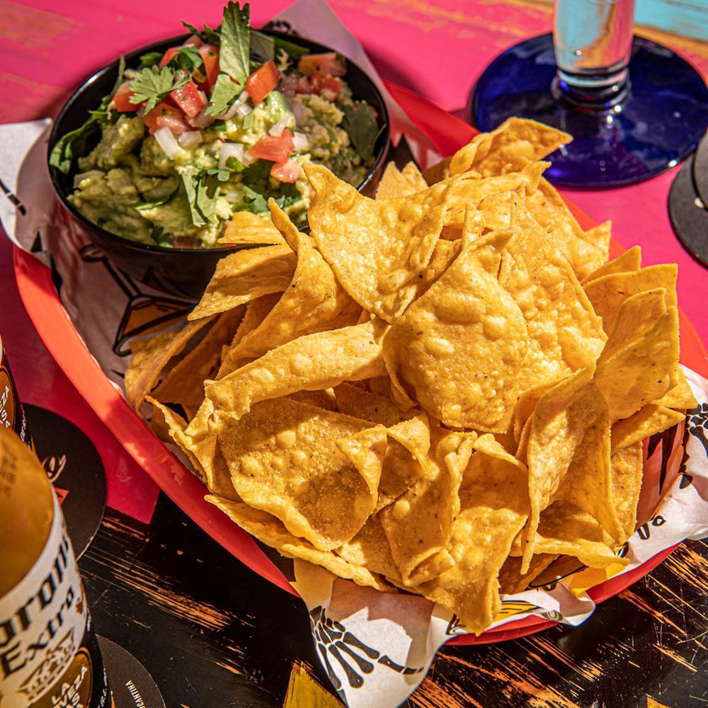 A bowl of tortilla chips and guac at El Camino Cantina.