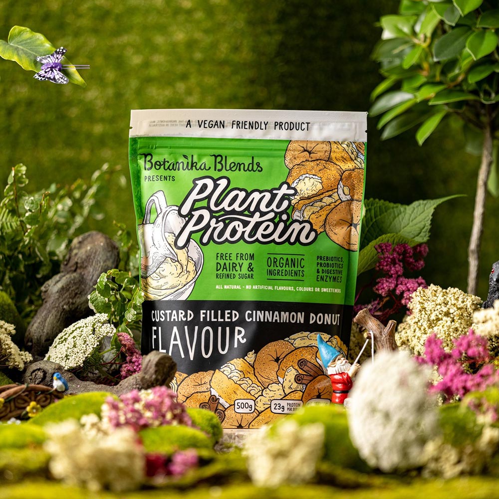 A pack of Botanika Blends plant-protein in amongst a forest/woodland setting.